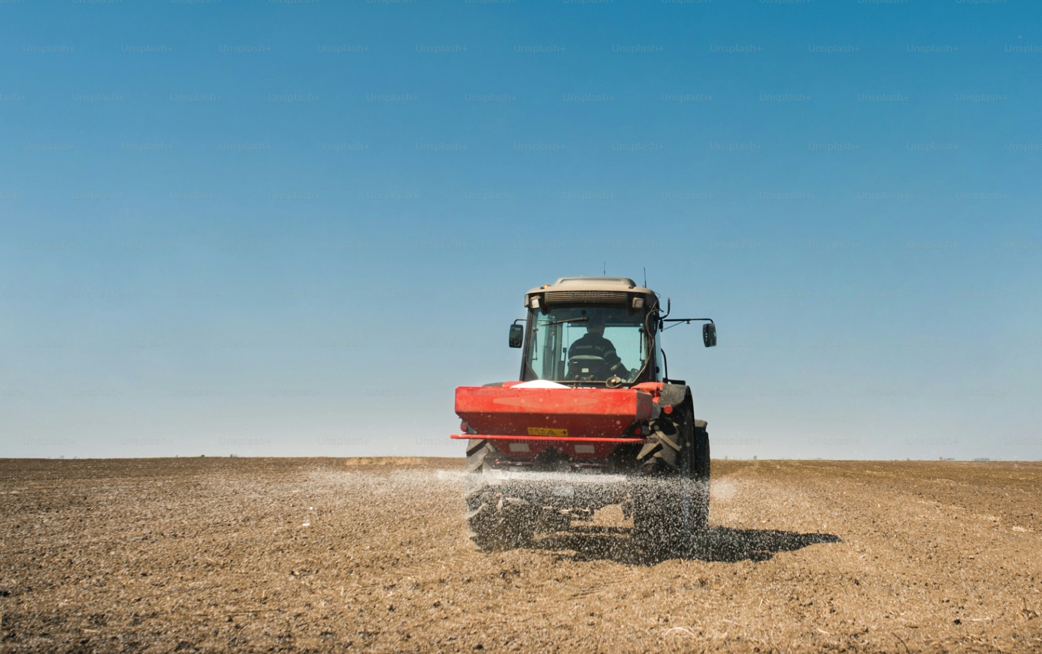 Red harvesting machine working in agricultural field